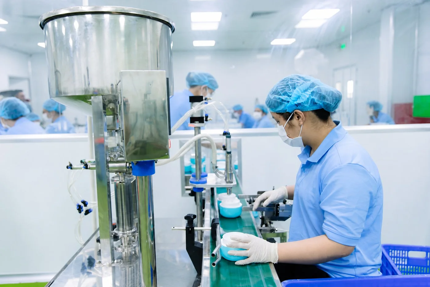 Nhân sự theo dõi hũ kem và máy chiết rót